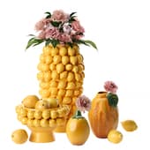 a set of bright yellow vases with lemons and a bouquet